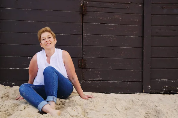 Mature woman sitting on seaside — Stock Photo, Image