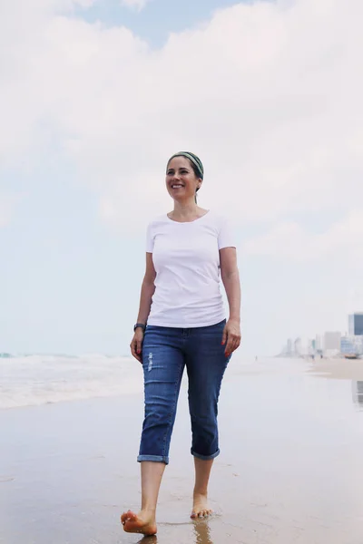 Rijpe vrouw lopen op zee — Stockfoto