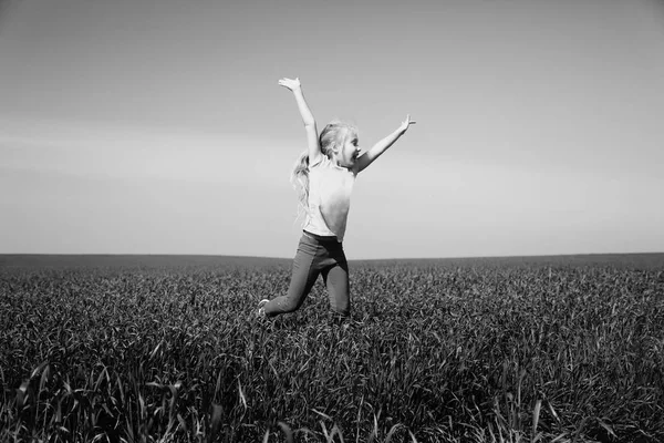 Menina pulando no campo — Fotografia de Stock