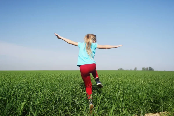 Flickan hoppar på fältet — Stockfoto