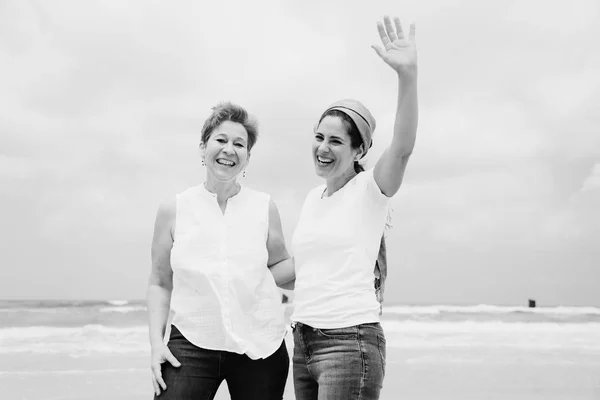 Zwei Frauen stehen am Strand — Stockfoto