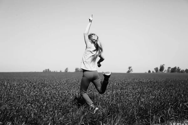 Mädchen springt auf Feld — Stockfoto