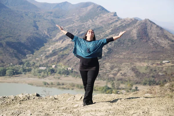 Portrait of beautiful middle-aged woman walking in autumn mountains at daytime