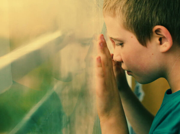 cute ten years old autistic boy looking at rain
