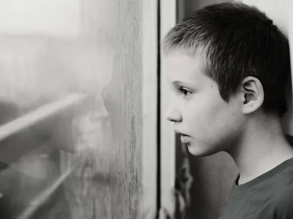 可爱的十岁孤独症男孩看着雨 黑白相间 — 图库照片