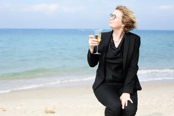 45歳の女性の肖像 シャンパンのガラスを保持ビーチで — ストック写真