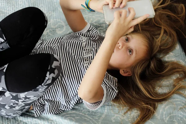 Covy ホームスクールのコンセプト 9歳の女の子は退屈しています自宅でとともに携帯電話 — ストック写真
