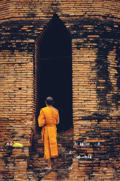 Mnich buddyjski, stojąc przed front stare ruiny Wat Ratburana — Zdjęcie stockowe