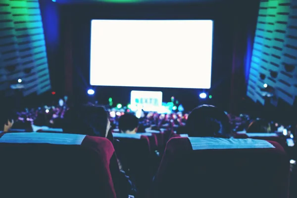 Cinema auditorium with people in chairs watching movie. High ang