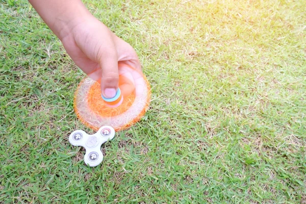 Chico sosteniendo jugar dos fidget spinners, Fidget spinner blanco y o —  Fotos de Stock