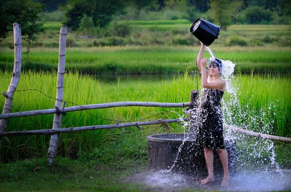 Сільська дівчина приймає душ з традиційної підземної води в — стокове фото