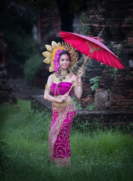 Hermosa chica con vestido tailandés y paraguas flor flujo espalda — Foto de Stock