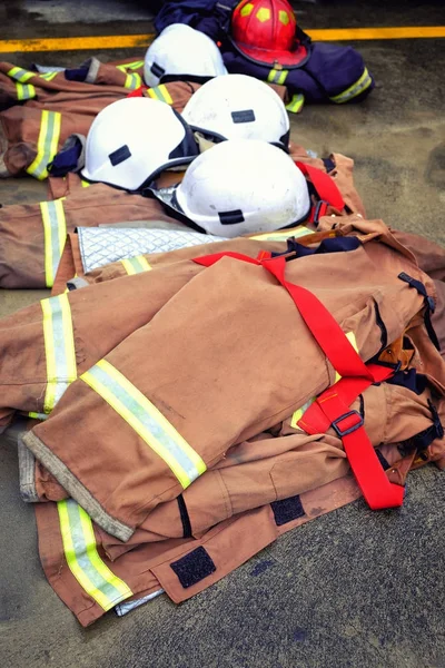 Zblízka kabát klobouk hasicí přístroj na zem. Po trun off v plamenech — Stock fotografie