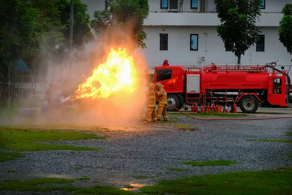 Instruktor, ukazující, jak používat hasicí přístroj na školení — Stock fotografie