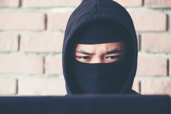 Закрыть лицо Хакер работает на своем компьютере, Хакер крадет папа — стоковое фото
