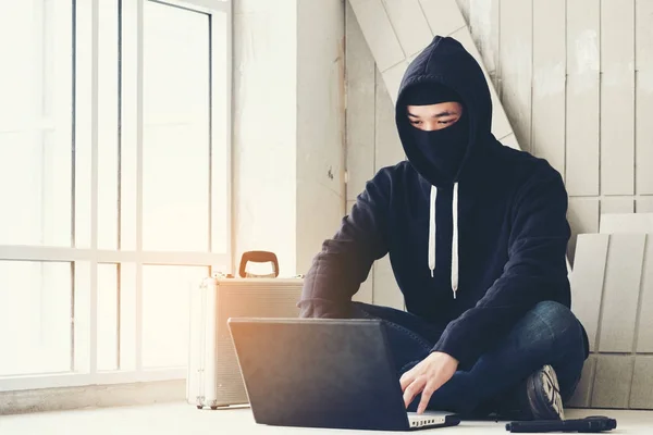 Hacker sosteniendo armas trabajando en su computadora, guerra, terrorismo, ter —  Fotos de Stock