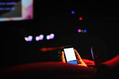 Adam cep telefonu ve bulanık görüntü ışık tiyatroda kullanın,