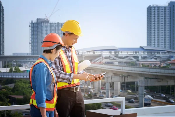 Man Engineers stand on tall buildings and talk about cell phones — Stock Photo, Image