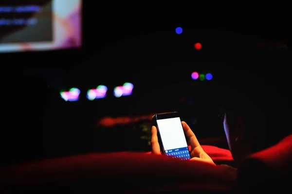 Adam cep telefonu ve bulanık görüntü ışık tiyatroda kullanın,