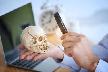 Genç doktor bir büyüteç ile ve insan skul izliyor