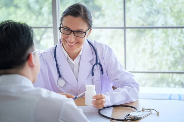 Senior Female doctor consults young Patient sitting at doctor of