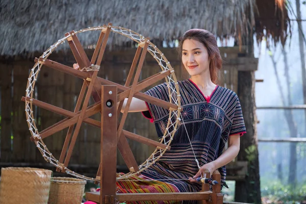 Mooie Thaise vrouwen glimlach in karen pak spinnen draad op een ba — Stockfoto