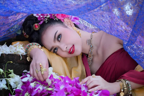 Mulher asiática bonita com vestido tradicional tailandês no fluxo de orquídea — Fotografia de Stock
