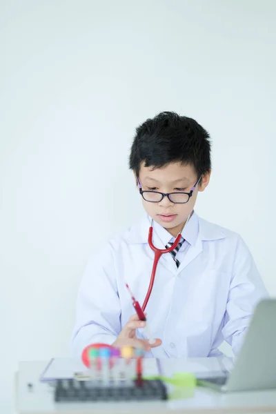 Little cute boy future doctor dressed white holding syringe with