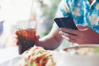 Erkekler oyun smartphone ve el cam meşrubat Cafe Restoran bekle gıda tutun