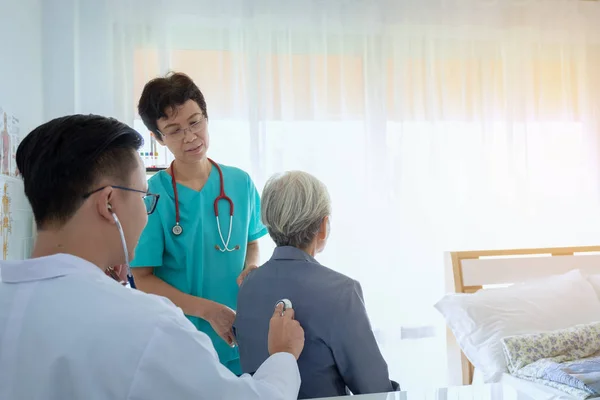Arzt untersucht Seniorin mit Stethoskop — Stockfoto