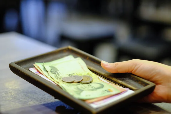 Close-up hand holding of Bill with Thai money banknote and coins — Stock Photo, Image