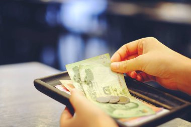 Bill yakın çekim el tutan Tay para banknot ve madeni paralar ile