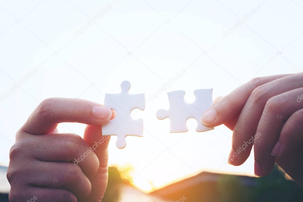 Closeup hand of woman connecting jigsaw puzzle with sunlight, sy