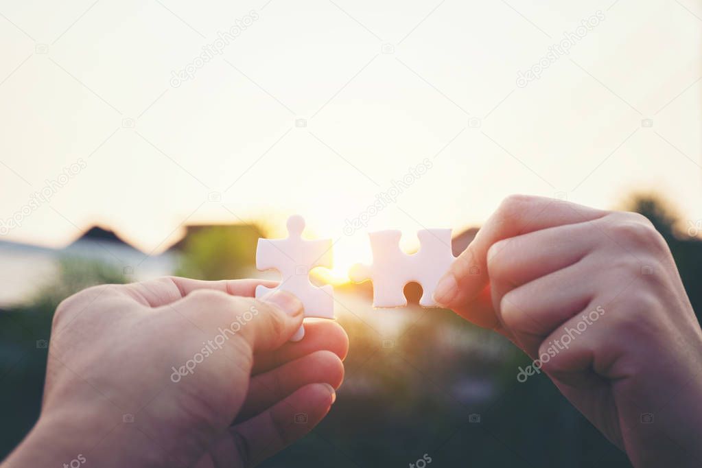 Closeup hand of woman connecting jigsaw puzzle with sunlight, sy