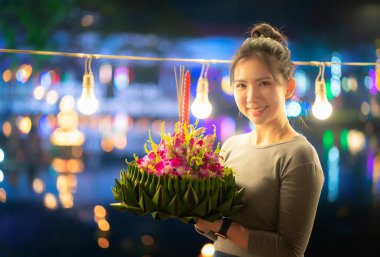 Tayland 'daki Loy Krathong festivallerinde güzel bir kadın Krathong' u muz yaprağıyla tutar.