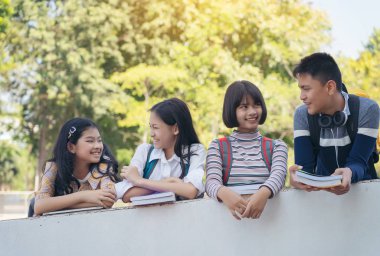 Bir grup öğrenci duvar geçidinde yan yana duruyorlar. 