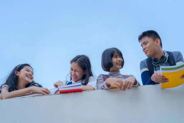 Группа студентов смеется, стоя вместе над стеной Walkwa — стоковое фото