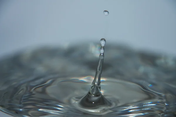 Wassertropfen fallen ins Wasser — Stockfoto