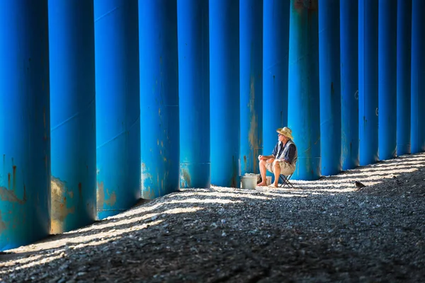 Ein Einsamer Fischer Auf Blauem Hintergrund Der Kolonnade Der Pfeife — Stockfoto