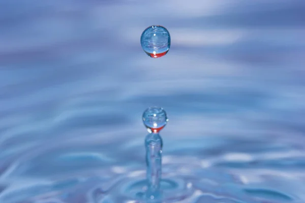 Wassertropfen fallen ins Wasser — Stockfoto