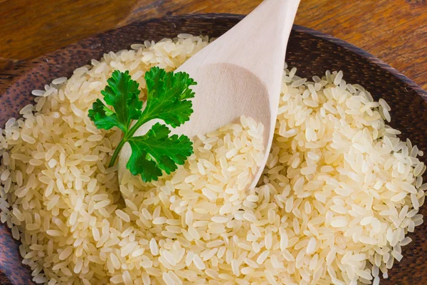 Ρύζι στο πιάτο με ξύλινο κουτάλι — Φωτογραφία Αρχείου