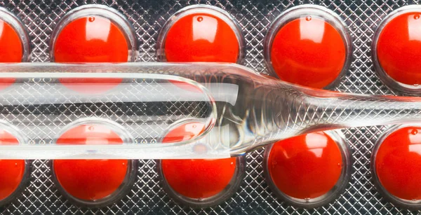 Ampul met geneesmiddelen op de achtergrond van tabletten — Stockfoto