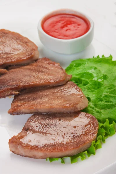 Gekookt rundvlees tong met groenten wordt geserveerd op een bord — Stockfoto