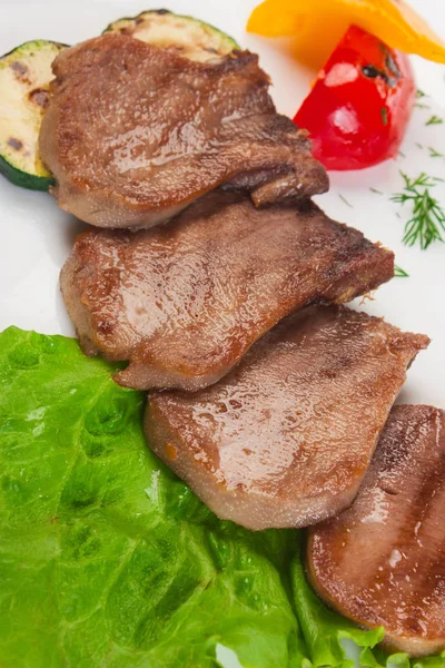 Kokt nötkött tungan med grönsaker serveras på en tallrik — Stockfoto