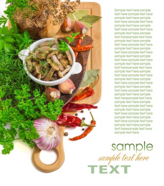 Kesme tahtasında marine edilmiş mantarlar ve beyaz arka planda izole edilmiş baharatlar.