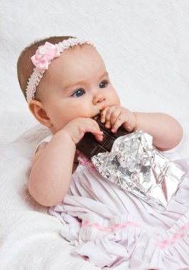 Elinde çikolata olan küçük kız.