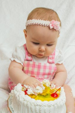 Elinde tatlı bir pastayla küçük bir kız