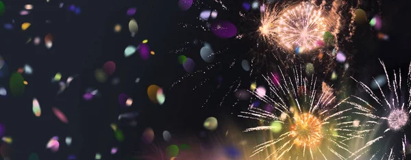 Brilhantes fogos de artifício multicoloridos espumantes e confetes panorama — Fotografia de Stock
