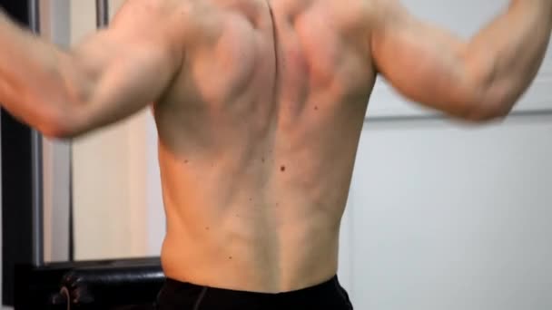 Молодий атлетичний чоловік виконує м'язові вправи — стокове відео