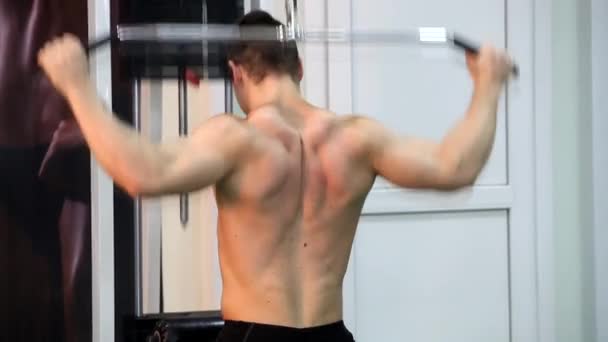 Молодий атлетичний чоловік виконує м'язові вправи — стокове відео